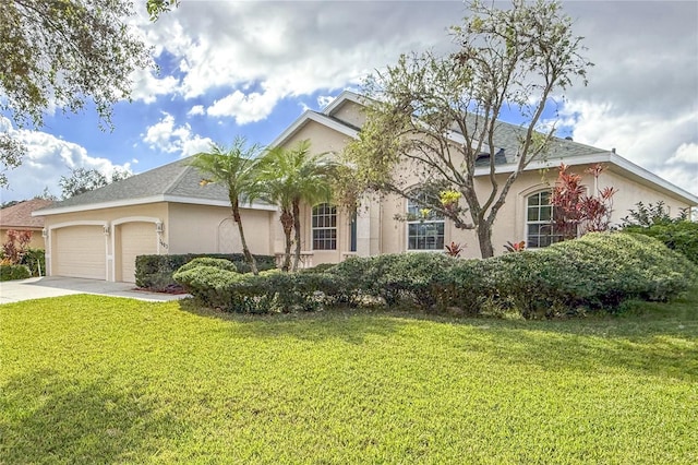 ranch-style home with concrete driveway, an attached garage, a front yard, and stucco siding