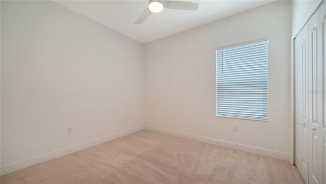 empty room with ceiling fan and light colored carpet