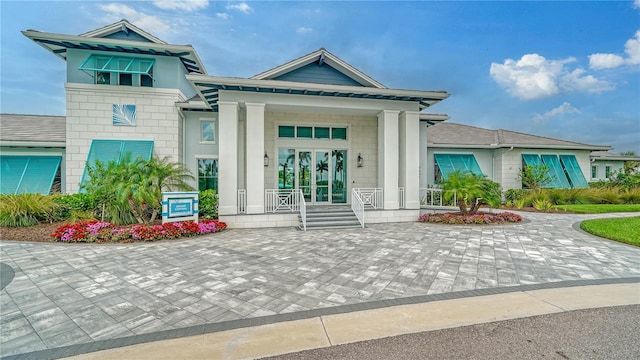 view of exterior entry with french doors and a porch