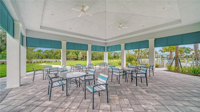 exterior space featuring a wealth of natural light, a tray ceiling, and ceiling fan