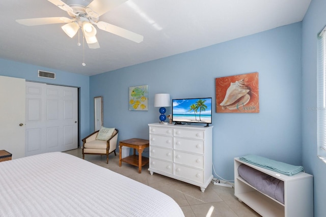 tiled bedroom with ceiling fan and a closet