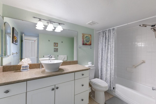 full bathroom featuring tile patterned floors, shower / tub combo with curtain, vanity, and toilet