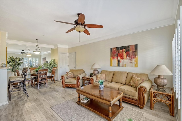 living room with light wood-type flooring, ceiling fan, and crown molding