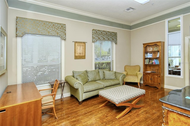 living room featuring hardwood / wood-style flooring, ornamental molding, and a textured ceiling