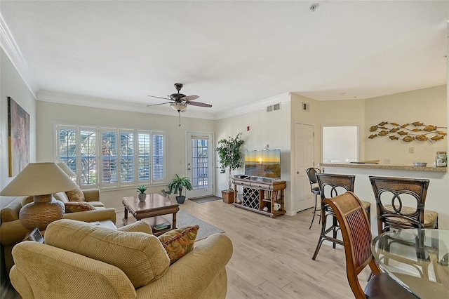 living room featuring light wood-type flooring, ceiling fan, and ornamental molding