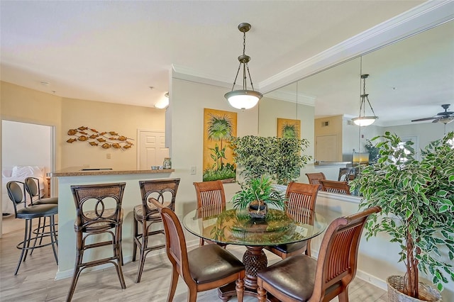 dining area with crown molding, ceiling fan, and light hardwood / wood-style flooring