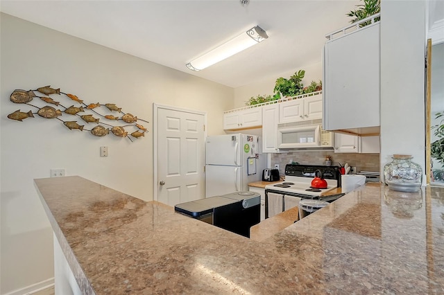 kitchen with white cabinetry, white appliances, kitchen peninsula, and tasteful backsplash