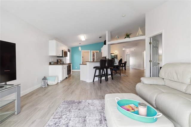 living room with light wood-type flooring and lofted ceiling