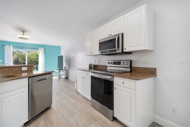 kitchen featuring dark stone countertops, sink, white cabinets, and stainless steel appliances