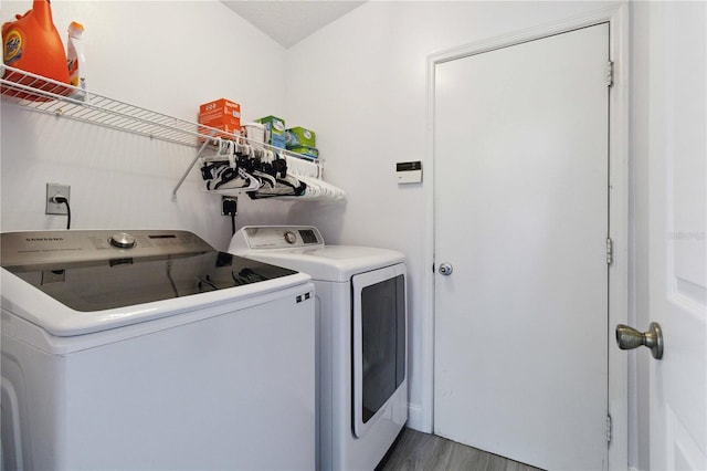 laundry room with washing machine and dryer and hardwood / wood-style floors