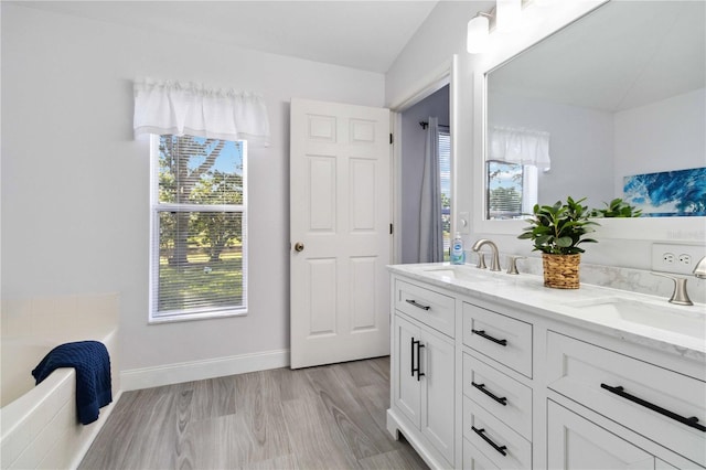 bathroom with hardwood / wood-style flooring, plenty of natural light, and lofted ceiling