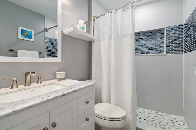 bathroom with curtained shower, vanity, and toilet