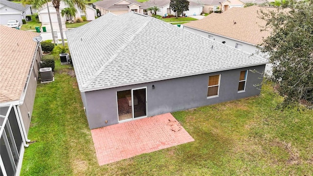 back of house featuring a lawn, a patio area, and central AC