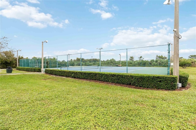 view of sport court with a lawn