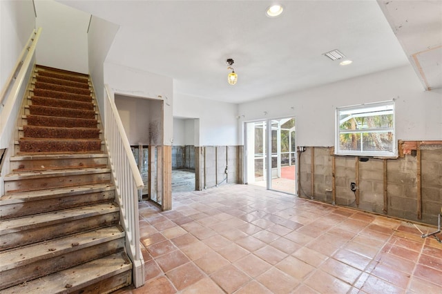 spare room with light tile patterned floors and tile walls