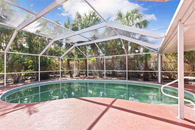 view of pool featuring glass enclosure and a patio