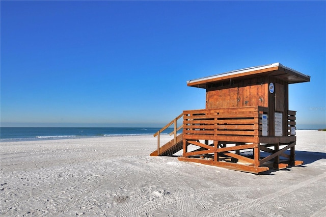 view of property's community with a water view and a view of the beach