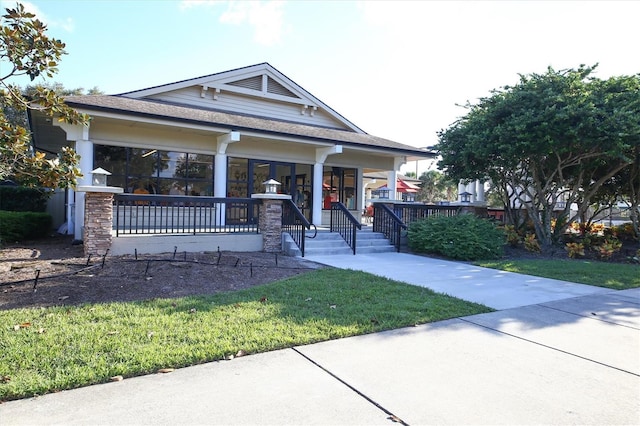 craftsman house featuring covered porch and a front yard