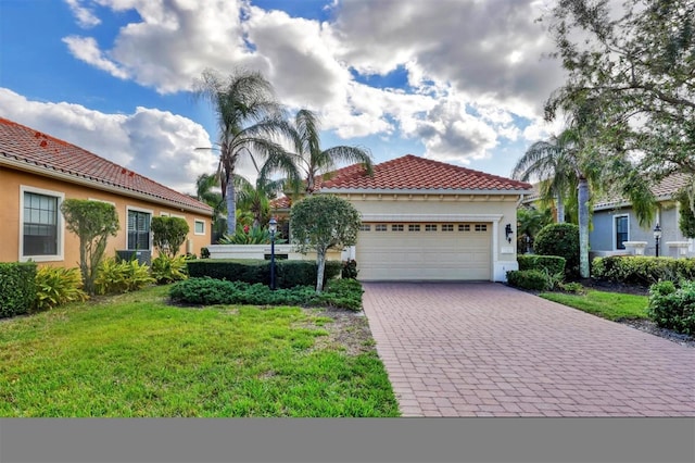 mediterranean / spanish home with a garage and a front lawn