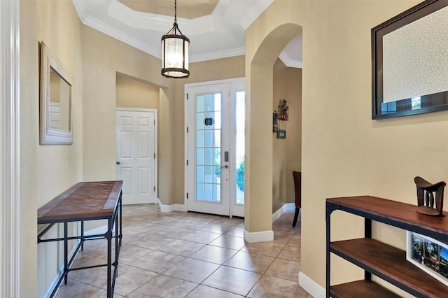 entrance foyer with a raised ceiling, crown molding, and light tile patterned floors