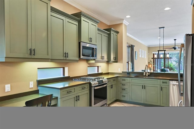 kitchen featuring kitchen peninsula, appliances with stainless steel finishes, sink, decorative light fixtures, and green cabinets