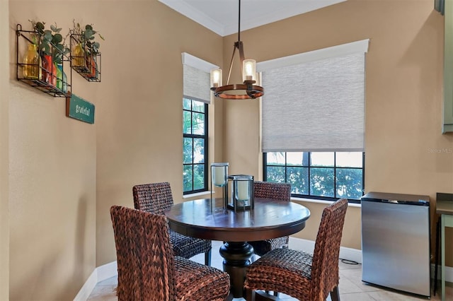 dining area featuring light tile patterned flooring, ornamental molding, and an inviting chandelier