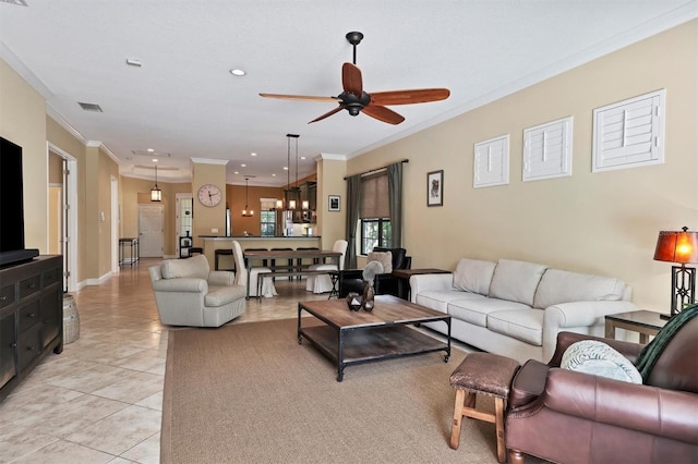 tiled living room with ceiling fan and ornamental molding