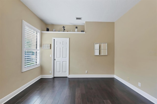 spare room with dark wood-type flooring