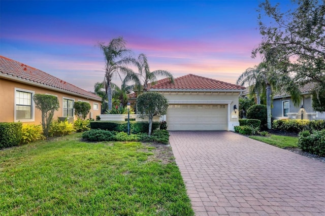 mediterranean / spanish house featuring a lawn and a garage