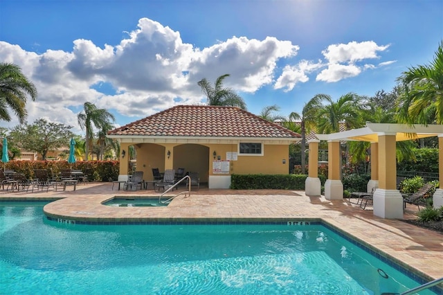 view of swimming pool featuring a community hot tub and a patio area