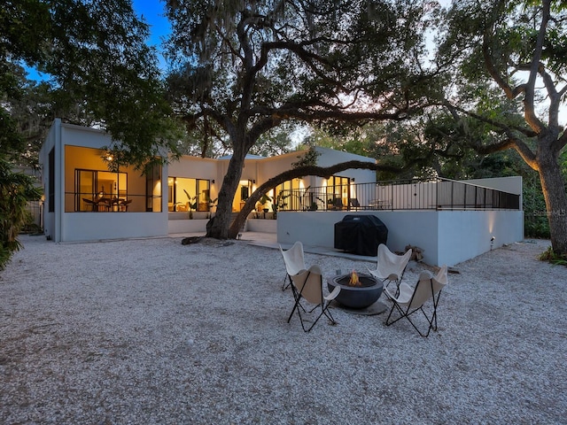 back of house featuring a fire pit and a patio