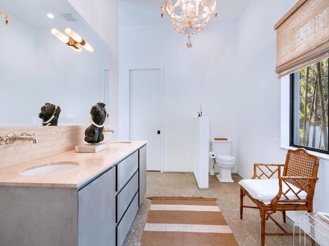 bathroom featuring vanity, a chandelier, and toilet