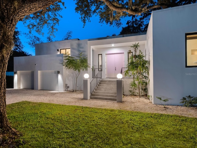 contemporary house featuring a garage and a front lawn