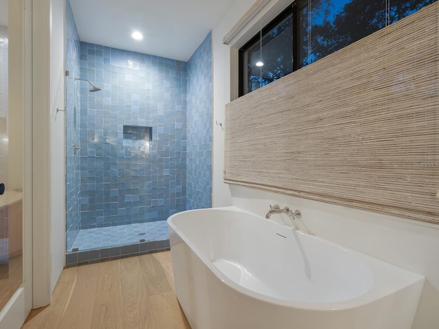 bathroom featuring separate shower and tub and wood-type flooring