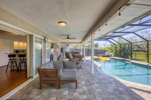 view of swimming pool featuring glass enclosure, a patio area, and exterior bar