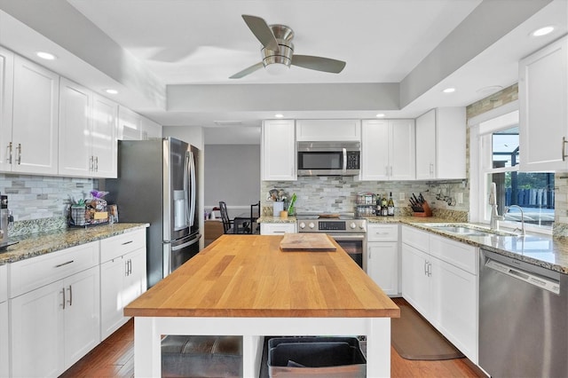 kitchen featuring white cabinets, appliances with stainless steel finishes, and hardwood / wood-style floors