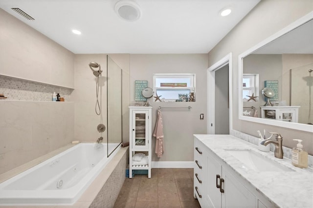 bathroom with tile patterned floors, vanity, and tiled shower / bath