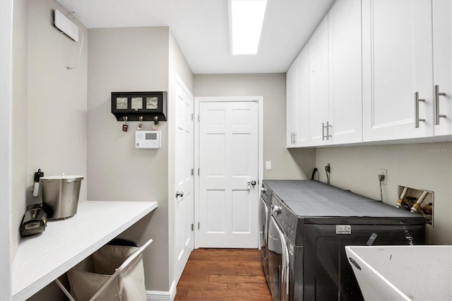 laundry area featuring washer and dryer, cabinets, and dark hardwood / wood-style floors