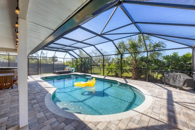 view of pool featuring glass enclosure and a patio area