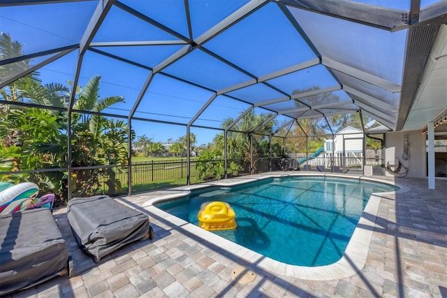 view of swimming pool featuring a patio, glass enclosure, and a storage unit