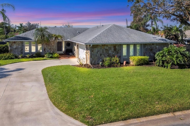 single story home featuring a lawn