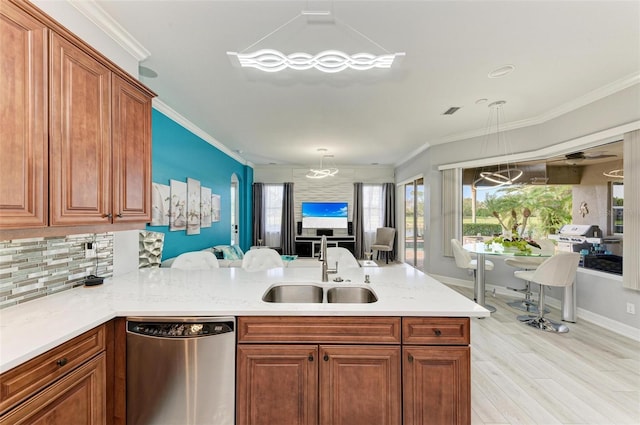 kitchen featuring ornamental molding, kitchen peninsula, hanging light fixtures, and sink