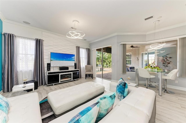 living room with crown molding, hardwood / wood-style floors, ceiling fan, and plenty of natural light