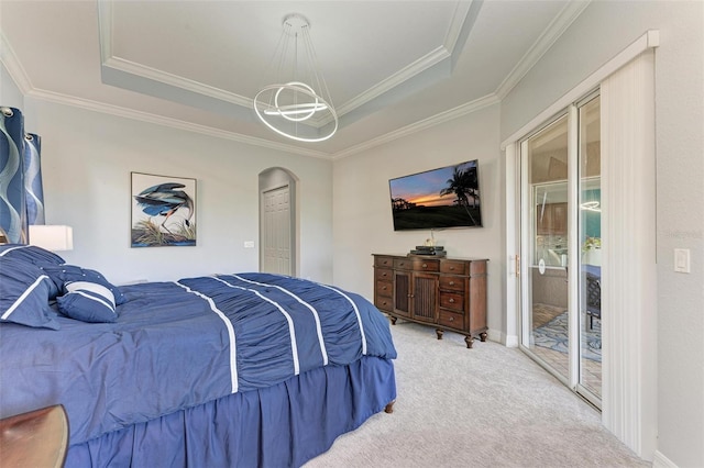 carpeted bedroom with ornamental molding and a tray ceiling