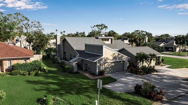 3410 Avenida Madera Unit B, Bradenton, FL 34210 - view of front of property featuring concrete driveway, roof with shingles, an attached garage, and a front lawn