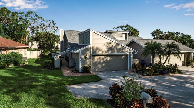3410 Avenida Madera Unit B, Bradenton, FL 34210 - view of front of property featuring concrete driveway, a garage, a chimney, and a shingled roof