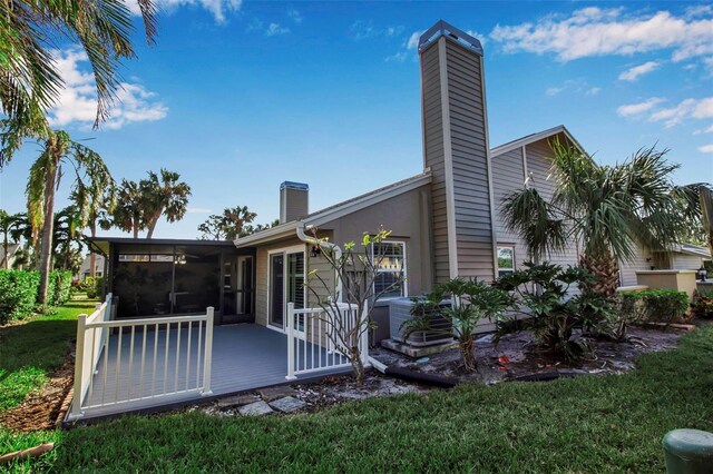 3410 Avenida Madera Unit B, Bradenton, FL 34210 - rear view of house featuring a chimney, a sunroom, a lawn, central air condition unit, and a deck