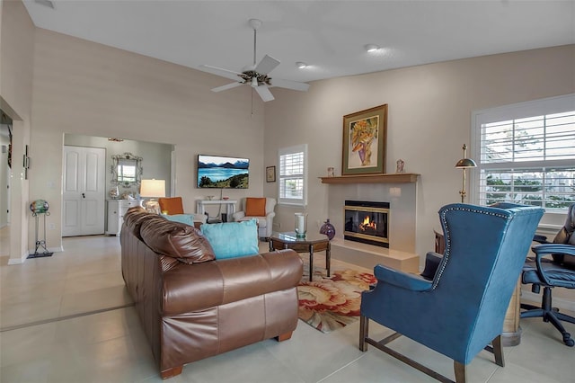 living room with high vaulted ceiling, ceiling fan, a healthy amount of sunlight, and light tile patterned flooring