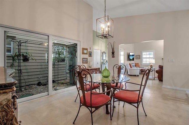 dining room with a towering ceiling and a notable chandelier