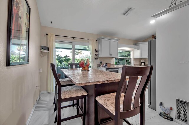 3410 Avenida Madera Unit B, Bradenton, FL 34210 - dining space with lofted ceiling, plenty of natural light, and baseboards